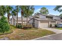 View of a townhouse with a one-car garage, mature landscaping, and a neatly manicured lawn at 411 Meadowood Blvd, Fern Park, FL 32730