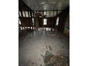 Interior view of a distressed property, revealing exposed wall studs and a ceiling fan at 509 Lemon St, Auburndale, FL 33823