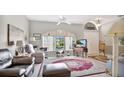 Inviting living room featuring tile floors, a ceiling fan, and a large arched window allowing natural light at 5203 Jasmine Trace Ln, Kissimmee, FL 34758