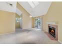 Inviting living room featuring vaulted ceilings, skylights, a fireplace, and sliding glass doors leading to the balcony at 6052 Westgate Dr # 204, Orlando, FL 32835
