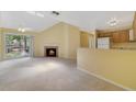 Bright living room featuring a cozy fireplace, sliding glass doors, and neutral carpet with a partial view of the kitchen at 6052 Westgate Dr # 204, Orlando, FL 32835