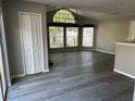 Open-concept living room with grey walls, wood-look flooring, large windows, and a closet at 652 Roaring Dr # 234, Altamonte Springs, FL 32714