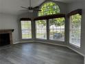 Bright living room with a ceiling fan, three large windows, grey walls, and a fireplace at 652 Roaring Dr # 234, Altamonte Springs, FL 32714