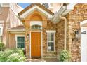 Inviting front entrance with a warm-toned door, stone accents, and well-manicured landscaping at 7521 Bay Port Rd # 12, Orlando, FL 32819