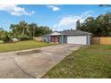 Attractive single-story home showcasing a green lawn, gray facade, and a vibrant red front door at 8 Lake Jackson Dr, Mascotte, FL 34753