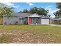 Lovely single-story home with a well-kept lawn, gray exterior, and an eye-catching red front door at 8 Lake Jackson Dr, Mascotte, FL 34753