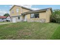 Image of a home with stone accents, a well-kept lawn, and front yard landscaping at 8652 Savory Dr, Orlando, FL 32825
