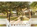 Street view in a charming neighborhood with mature trees and a picket fence at 911 S Oak Ave, Sanford, FL 32771