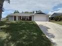 Single-story home with a two-car garage, gray and brick exterior, and a well-manicured front lawn at 943 Millenbeck Ave, Deltona, FL 32725