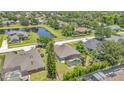Aerial view of property featuring a screened-in pool, lush landscaping, and neighborhood pond at 10417 Oakview Pointe Ter, Gotha, FL 34734