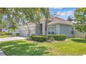 Landscaped front yard showcases this single-story home with an attached three-car garage, enhancing curb appeal at 10417 Oakview Pointe Ter, Gotha, FL 34734