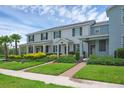 Inviting townhomes featuring well-manicured lawns, shrubbery, and charming brick walkways leading to the front doors at 11812 Metaphor Aly, Orlando, FL 32832