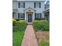 Inviting townhome featuring a well-manicured lawn and a charming brick pathway leading to the front door at 11812 Metaphor Aly, Orlando, FL 32832