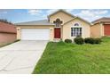 Charming single-Gathering home features an attached garage and well-manicured lawn at 1199 Stoneham Dr, Groveland, FL 34736