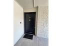A black door with a 'hello' doormat, complemented by a textured wall at 124 Springwood Cir # B, Longwood, FL 32750