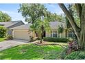 Charming single-story home with an attached garage, well-maintained lawn and appealing landscaping features at 1354 Dutch Elm Dr, Altamonte Springs, FL 32714