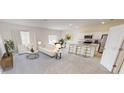 Open concept living space with modern furnishings, white kitchen, and sunny breakfast nook at 1397 Dalkeith Cv, Sanford, FL 32771