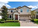 Charming two-story home with a well-manicured front yard, a brick driveway, and a two-car garage at 1421 Wexford Way, Davenport, FL 33896