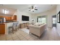 Cozy living room with tiled floors, a ceiling fan, and sliding glass doors leading to the outdoor patio at 15309 Markham Dr, Clermont, FL 34714