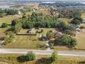 Expansive aerial view of the property featuring multiple buildings, open land, and fencing for added privacy at 16017 Johns Lake Rd, Clermont, FL 34711