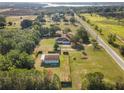Wide aerial view of property with separate outbuilding, mature trees, and road access, offering space and convenience at 16017 Johns Lake Rd, Clermont, FL 34711