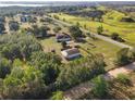 Scenic aerial view showcasing the property, outbuildings, lush greenery, and proximity to roads at 16017 Johns Lake Rd, Clermont, FL 34711