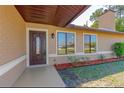 A covered porch leads to an elegant front door, framed by sidelight windows and landscaping at 1842 Evergreen Dr, Edgewater, FL 32141