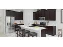 Modern kitchen with stainless steel appliances, a large center island, and dark wood cabinetry at 1851 Blissful Dr, Kissimmee, FL 34744