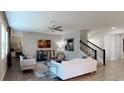 Comfortable living room with elegant furnishings, a staircase, and sophisticated wall decor at 1851 Blissful Dr, Kissimmee, FL 34744