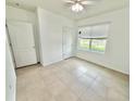 Bright bedroom featuring neutral tile flooring, and a large window providing natural light at 238 Miniehaha Cir, Haines City, FL 33844