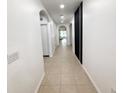 Bright hallway with neutral tile flooring and arched doorways leading to various rooms at 238 Miniehaha Cir, Haines City, FL 33844