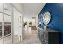 Elegant foyer with a decorative wall panel, a statement mirror, and neutral tile flooring at 2401 Oxmoor Dr, Deland, FL 32724