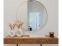 Close-up of an entryway with stylish decor, round mirror, and floating wood shelf at 2923 Banana Palm Dr, Kissimmee, FL 34747