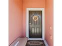Inviting front door featuring seasonal wreath, a bench, and a 