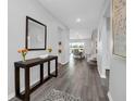 Spacious entryway featuring wood floors, a console table with decorative items, and an open view of the dining area at 3082 Mahalo Dr, Davenport, FL 33897