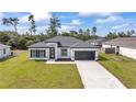 Beautiful home with a well-manicured lawn, gray roof, and a spacious two-car garage at 3211 Sw 128Th Street Rd, Ocala, FL 34473