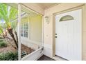 A close up of the house's front door, protected by a screened in porch with tropical foliage at 3304 Vancouver Ave, Deltona, FL 32738