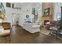 Open-concept living room featuring a soaring ceiling, spiral staircase, fireplace, and beautiful wood floors at 3501 Danby Ct, Orlando, FL 32812