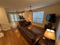 Spacious living room features hardwood floors, a ceiling fan, and flows into the adjacent kitchen at 3963 Turow Ln, Orlando, FL 32828