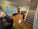 Comfortable living room with hardwood floors, a sofa, and a staircase leading to the upper level at 3963 Turow Ln, Orlando, FL 32828