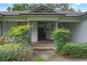 Inviting front porch with brick flooring and elegant columns, surrounded by lush greenery for a welcoming entrance at 432 Valley View Dr, Winter Garden, FL 34787
