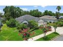 Well-maintained home featuring a lush lawn, colorful landscaping, and a three-car garage for added convenience at 468 Alinole Loop, Lake Mary, FL 32746