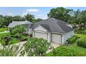 This home features an attached three-car garage, a well-maintained lawn, and lush landscaping around the property at 468 Alinole Loop, Lake Mary, FL 32746