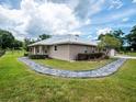 Charming home exterior with a stone walkway leading to the entrance, complemented by manicured landscaping at 485 Nw 71St Ave, Ocala, FL 34482