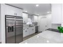 Modern kitchen with stainless steel appliances, granite countertops, and stylish white cabinetry at 657 Lear Ter, Deltona, FL 32725