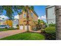 Charming two-story home with a brick driveway, lush landscaping and a wrought-iron fence at 7411 Excitement Dr, Reunion, FL 34747