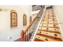 Elegant staircase with decorative tile risers, iron railing, and hardwood treads at 7411 Excitement Dr, Reunion, FL 34747