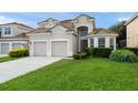 Charming two-story home featuring a tile roof, two-car garage, and well-maintained landscaping at 7754 Teascone Blvd, Kissimmee, FL 34747