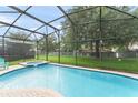 Relaxing screened-in pool and spa with a spacious patio and lush backyard view at 7754 Teascone Blvd, Kissimmee, FL 34747
