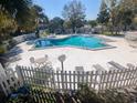 Community pool with ample deck space and lounge chairs, enclosed by a white picket fence for added privacy at 7900 S Orange Blossom Trl # 1099, Orlando, FL 32809